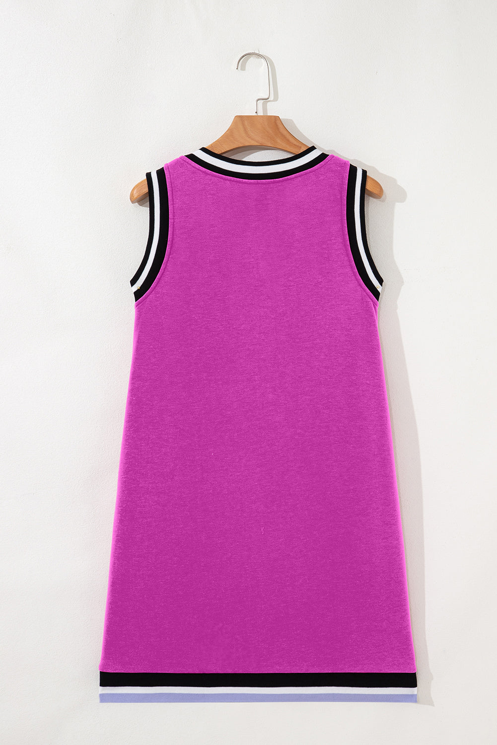 Sleeveless magenta dress with black and white striped collar and hem, hanging on hanger