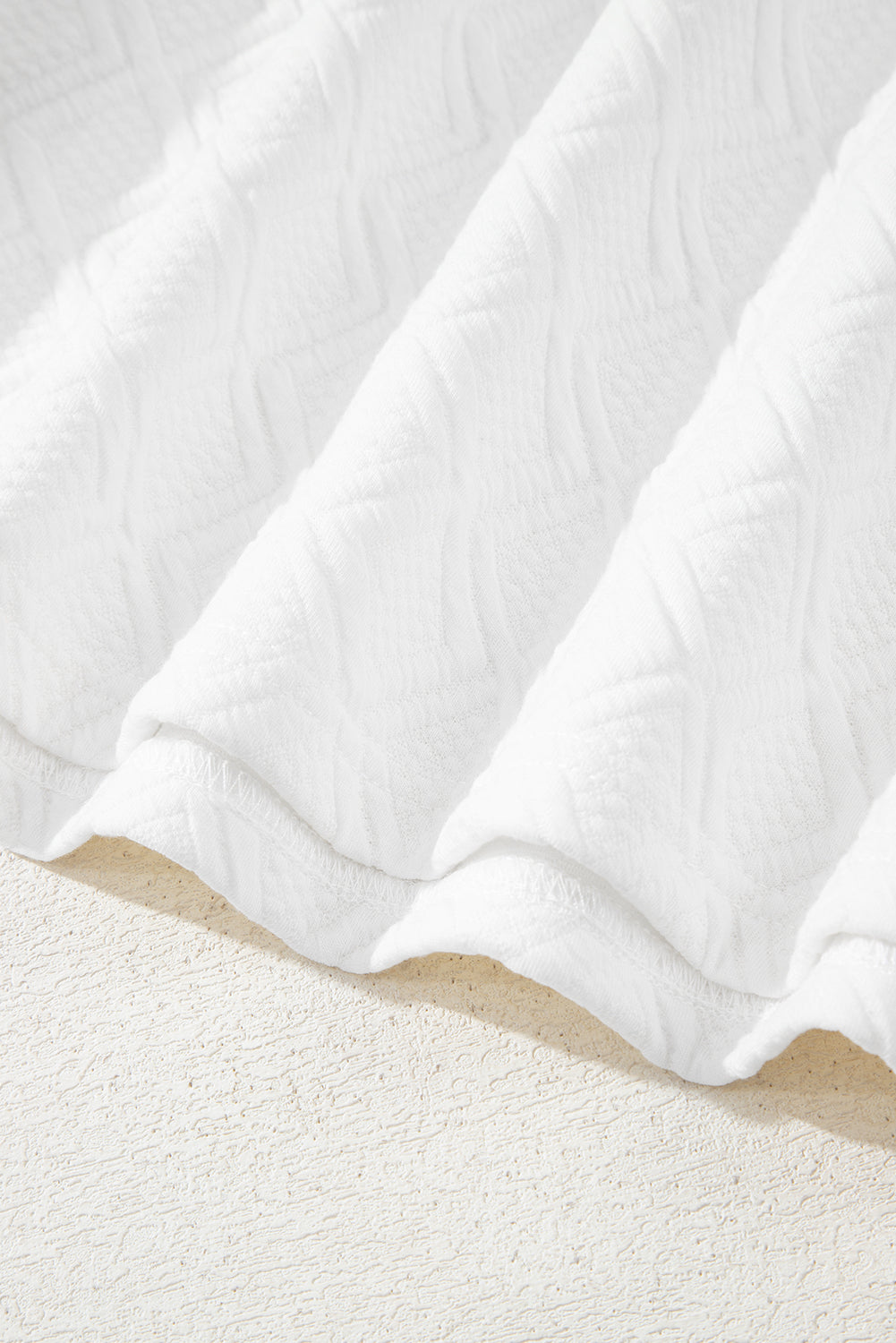 White textured fabric with geometric pattern, soft material on light background