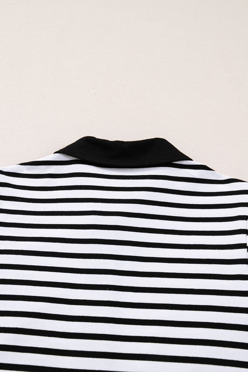 Black and white horizontal striped shirt with black collar, close-up back view