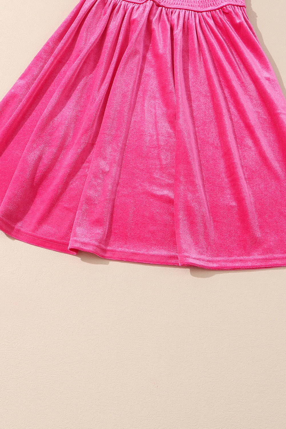 Bright pink velvet skirt with gathered waist on beige background