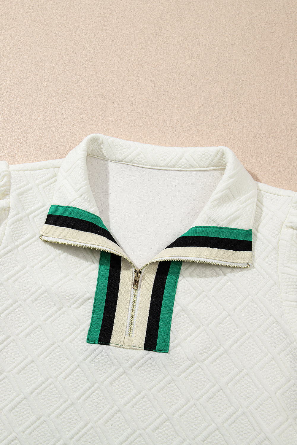 White textured zip collar top with green and black striped detail on the collar