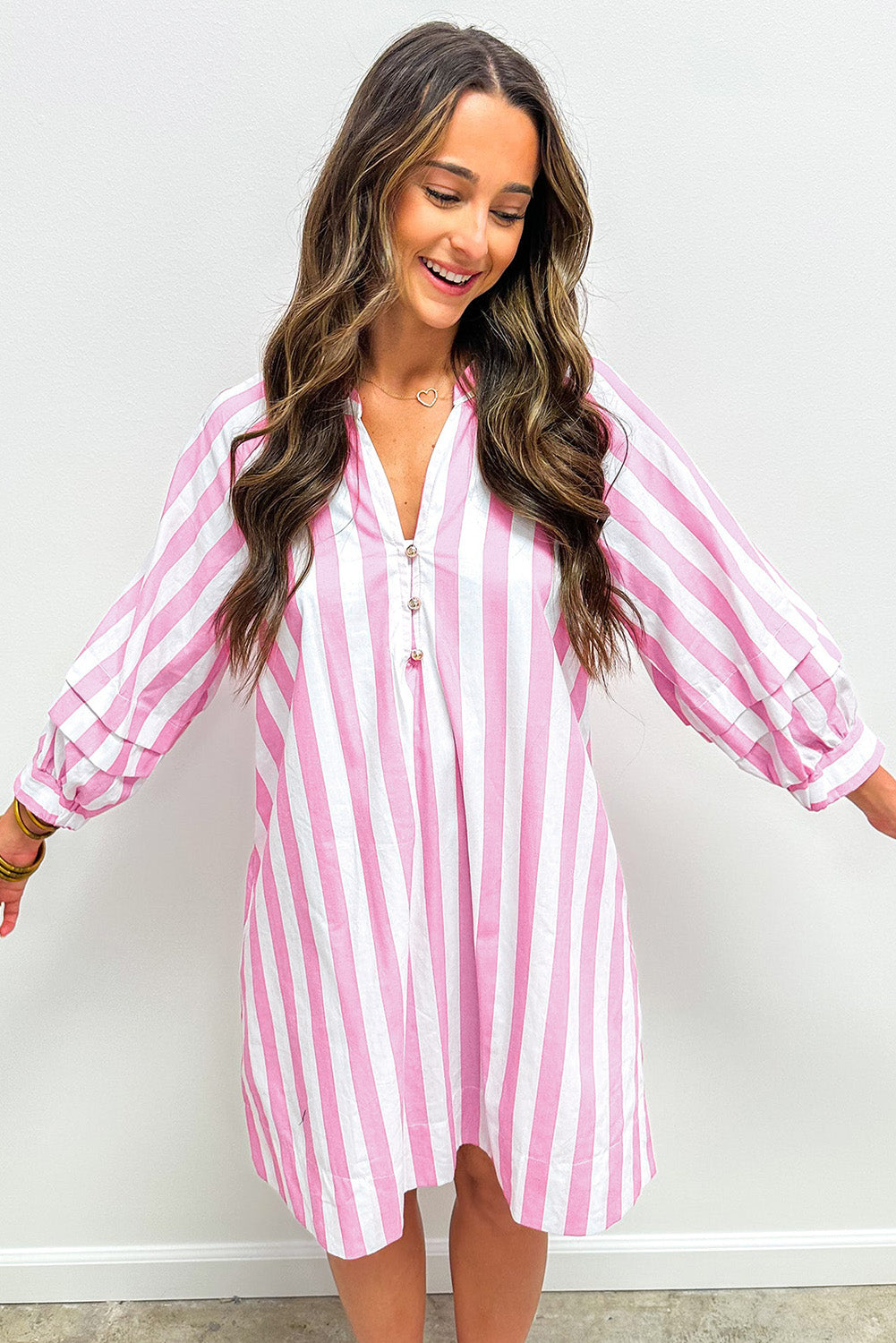 Woman wearing a pink and white vertical striped long sleeve dress