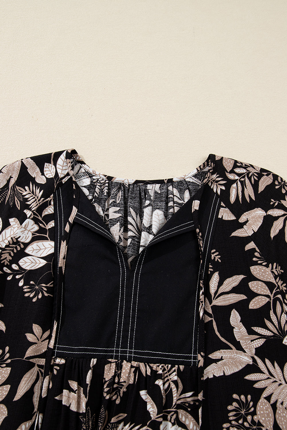 Black and beige floral print dress with square neckline and white stitching detail