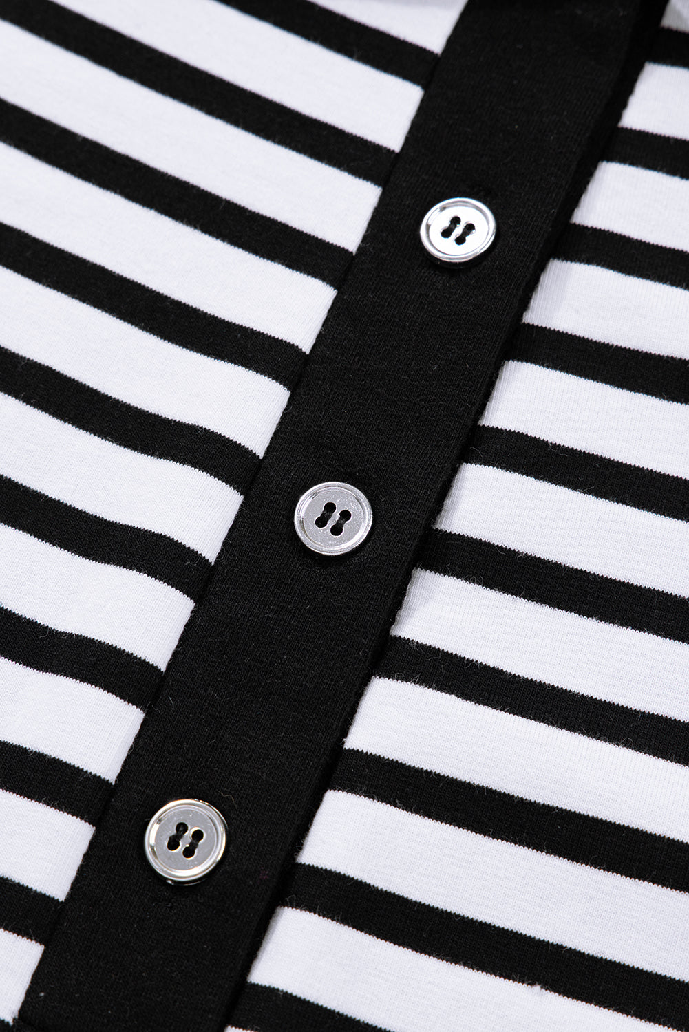 Close-up of black and white striped shirt with black placket and silver buttons