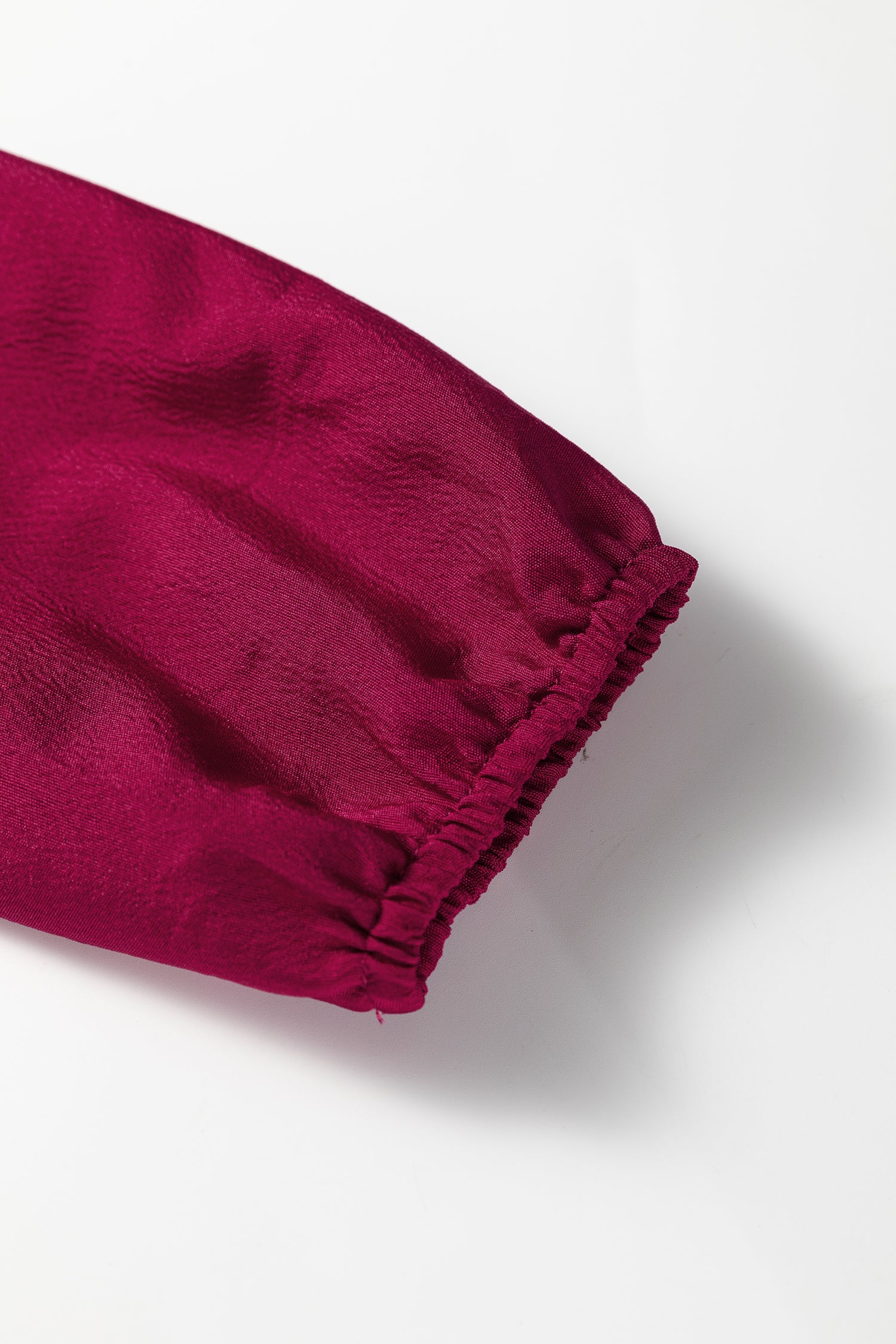 Close-up of magenta long sleeve with elastic cuff on white background