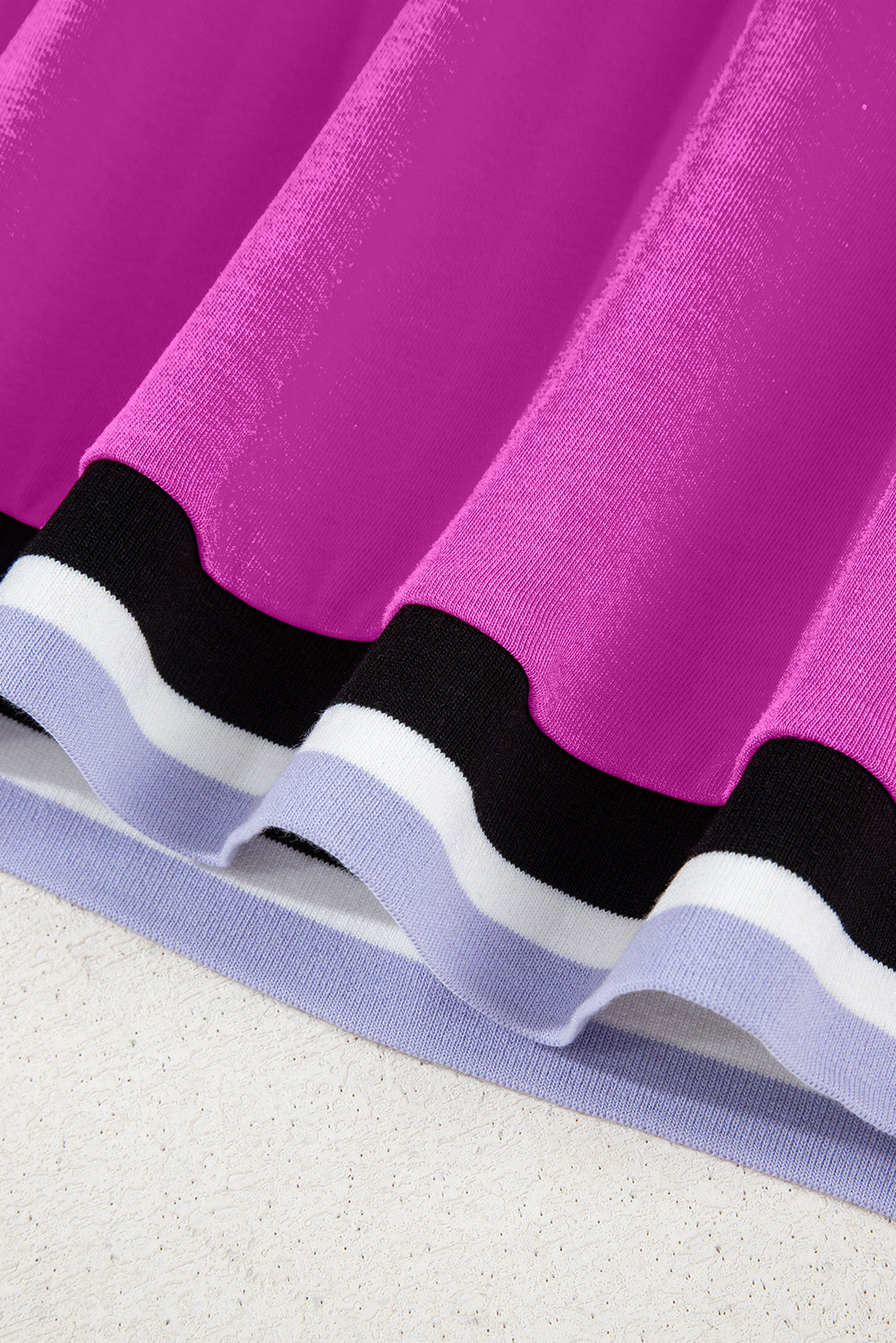 Pleated skirt hem in magenta with black, white, and lavender colorblock stripes