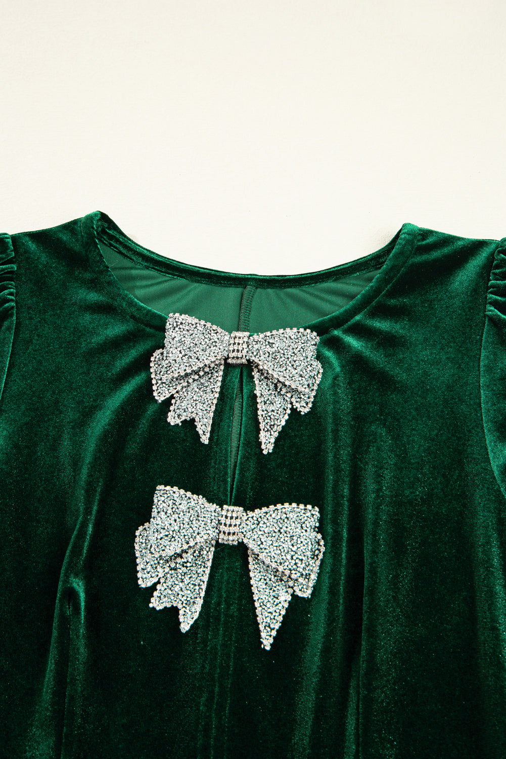 Green velvet dress with crystal bow embellishments on the front bodice