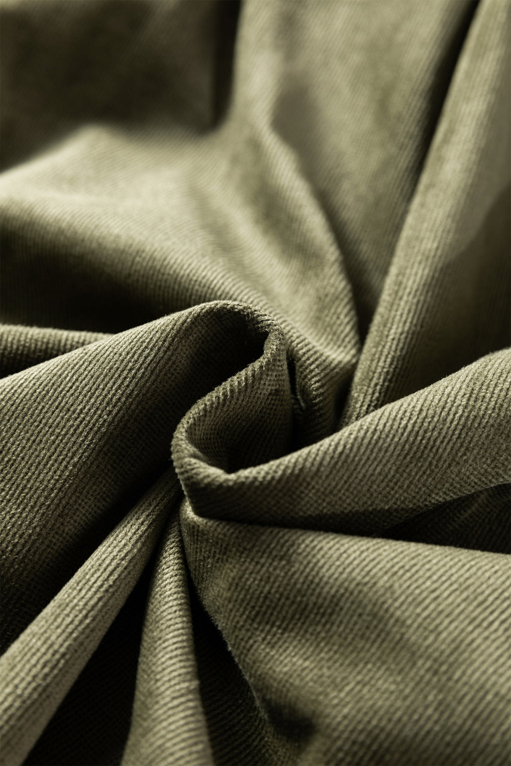 Close-up of olive green corduroy fabric texture with soft folds