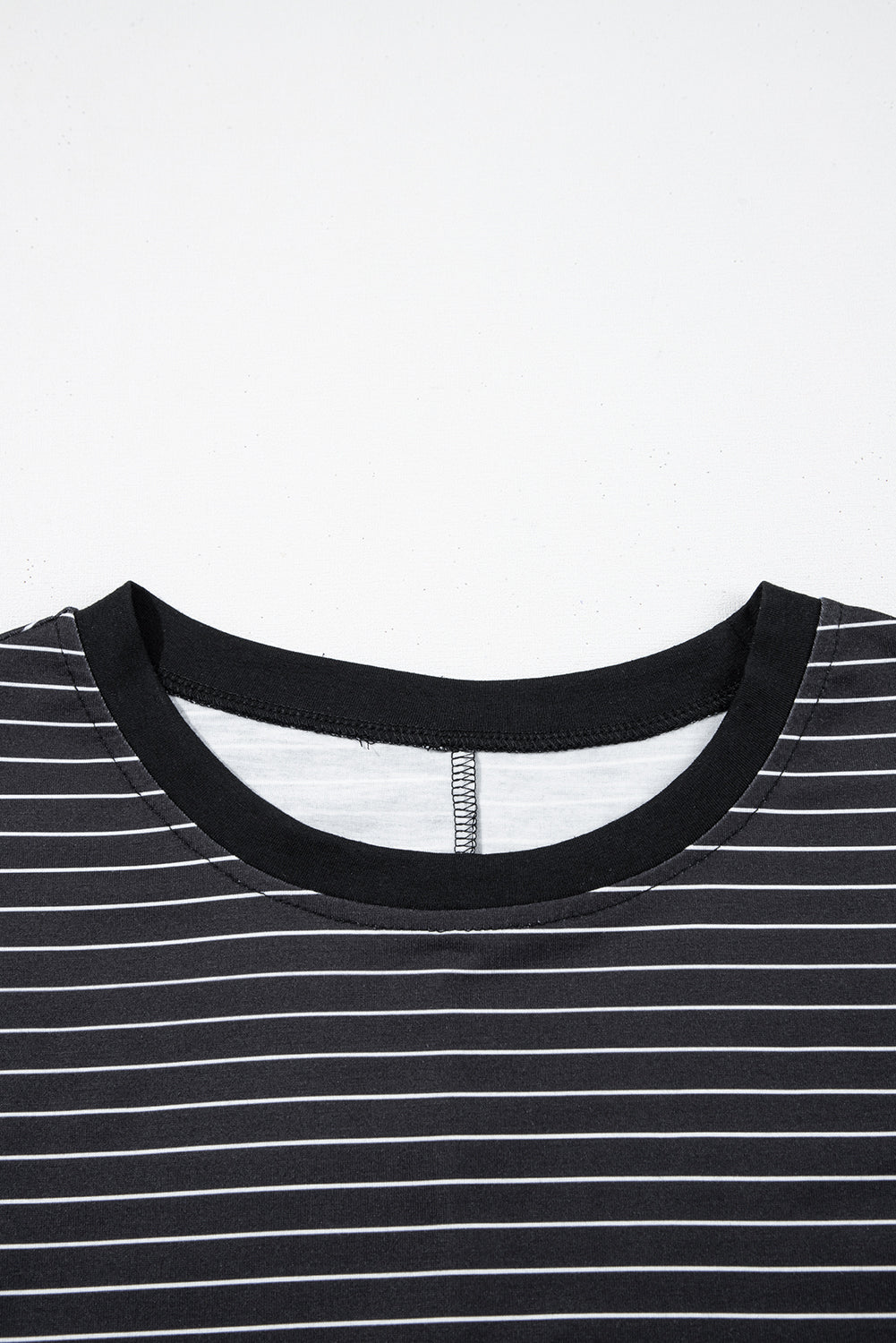 Black crew neck t-shirt with white horizontal stripes, close-up of neckline