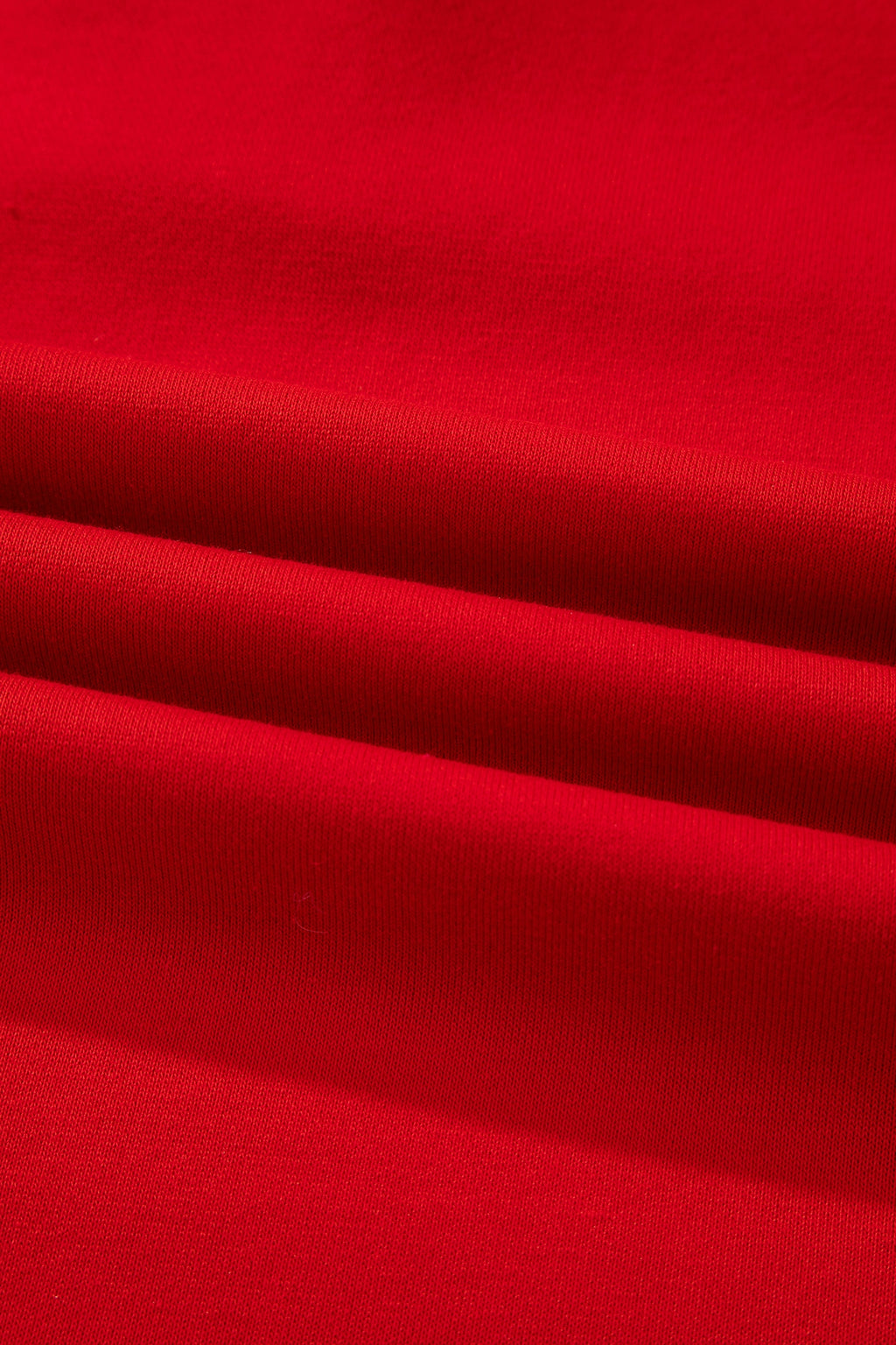 Close-up of soft red cotton fabric with visible texture and folded layers