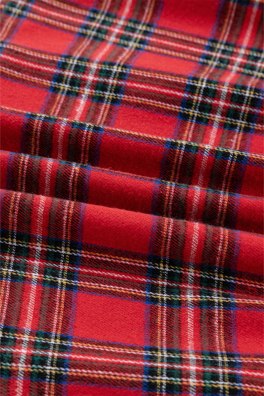Red plaid fabric with green, white, blue, and yellow checkered pattern, textured textile