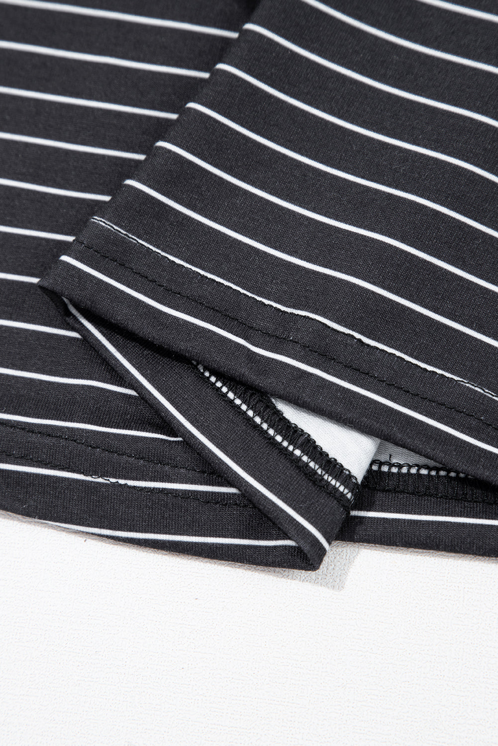 Close-up of black and white striped fabric with neat stitching, soft cotton material