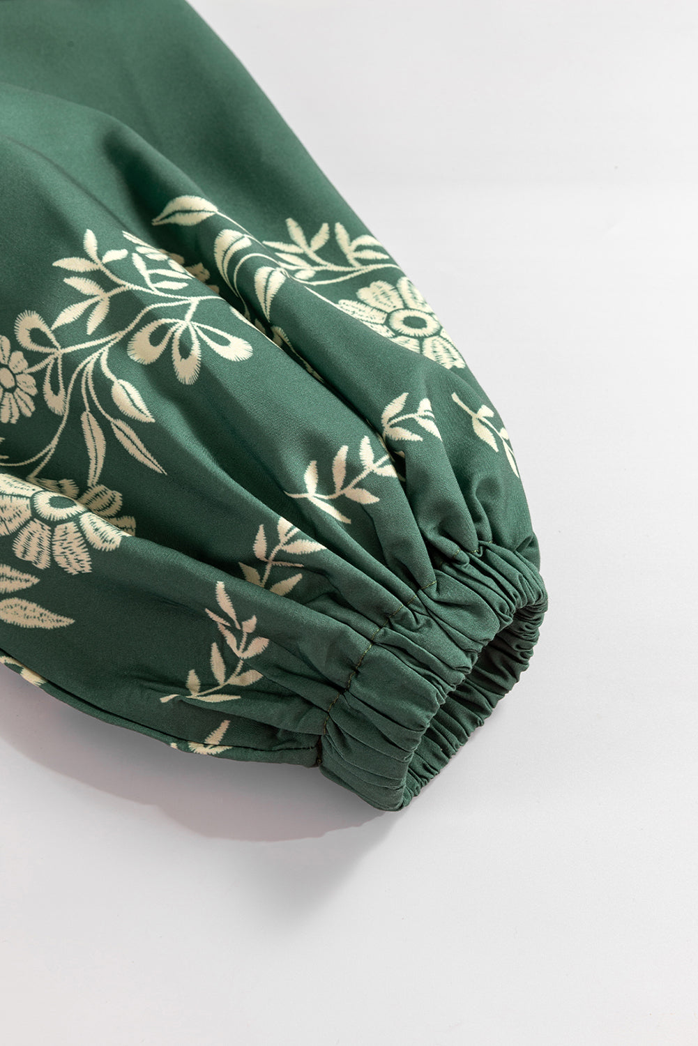 Green sleeve with floral embroidery and elastic cuff on white background