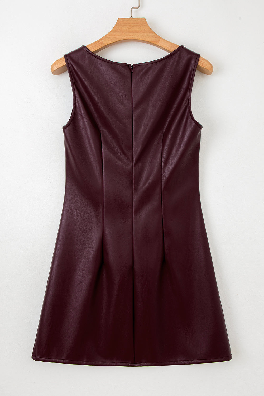 Sleeveless burgundy faux leather dress with back zipper on wooden hanger