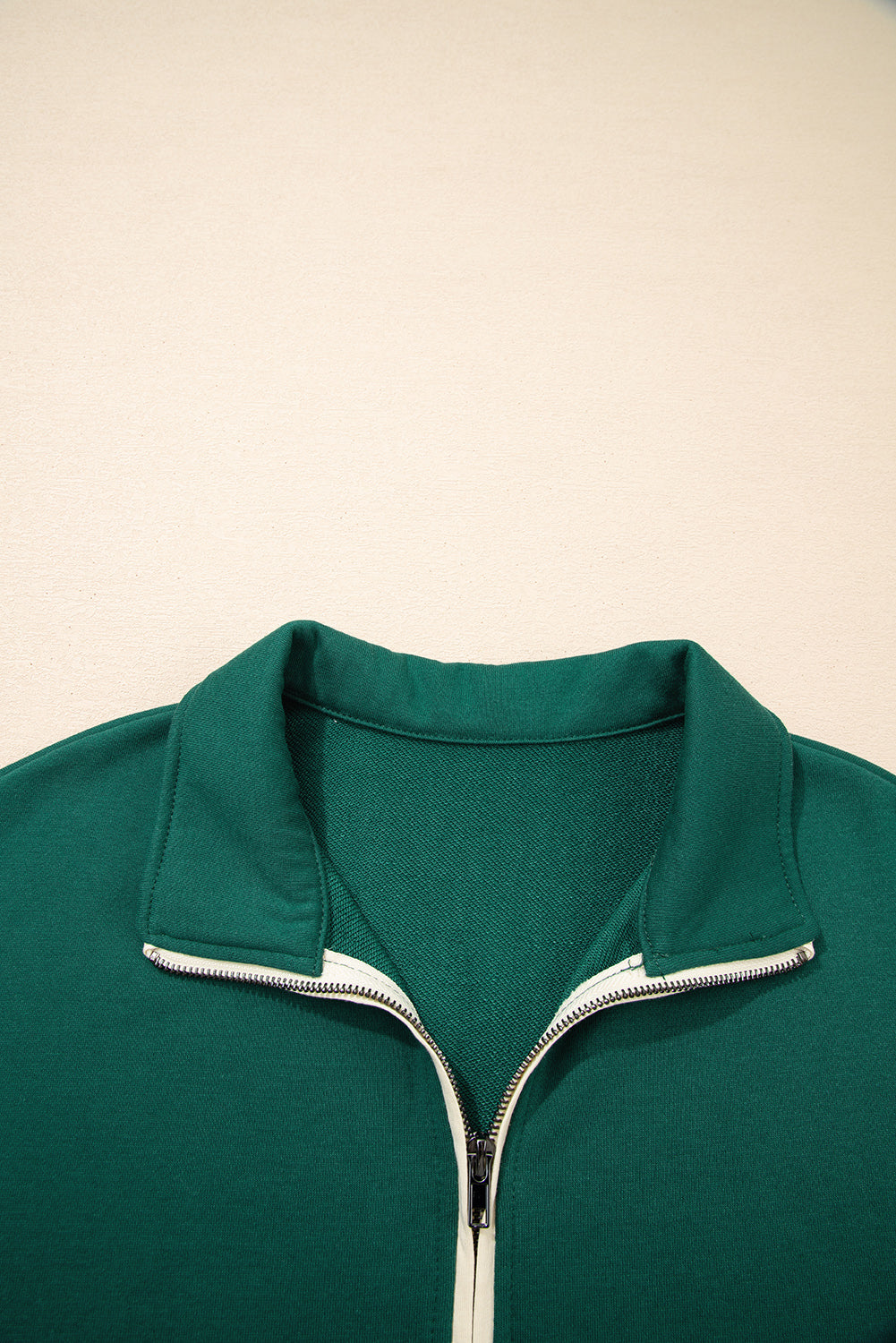 Green zip-up sweatshirt with collar on beige background