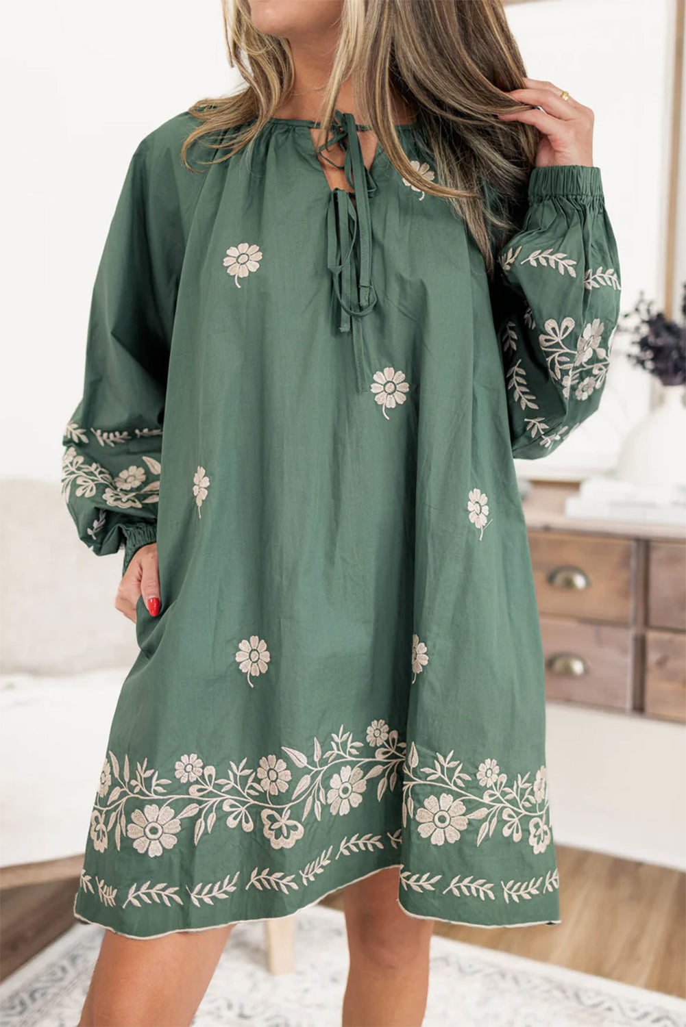 Woman wearing green long sleeve dress with white floral embroidery, boho style fashion