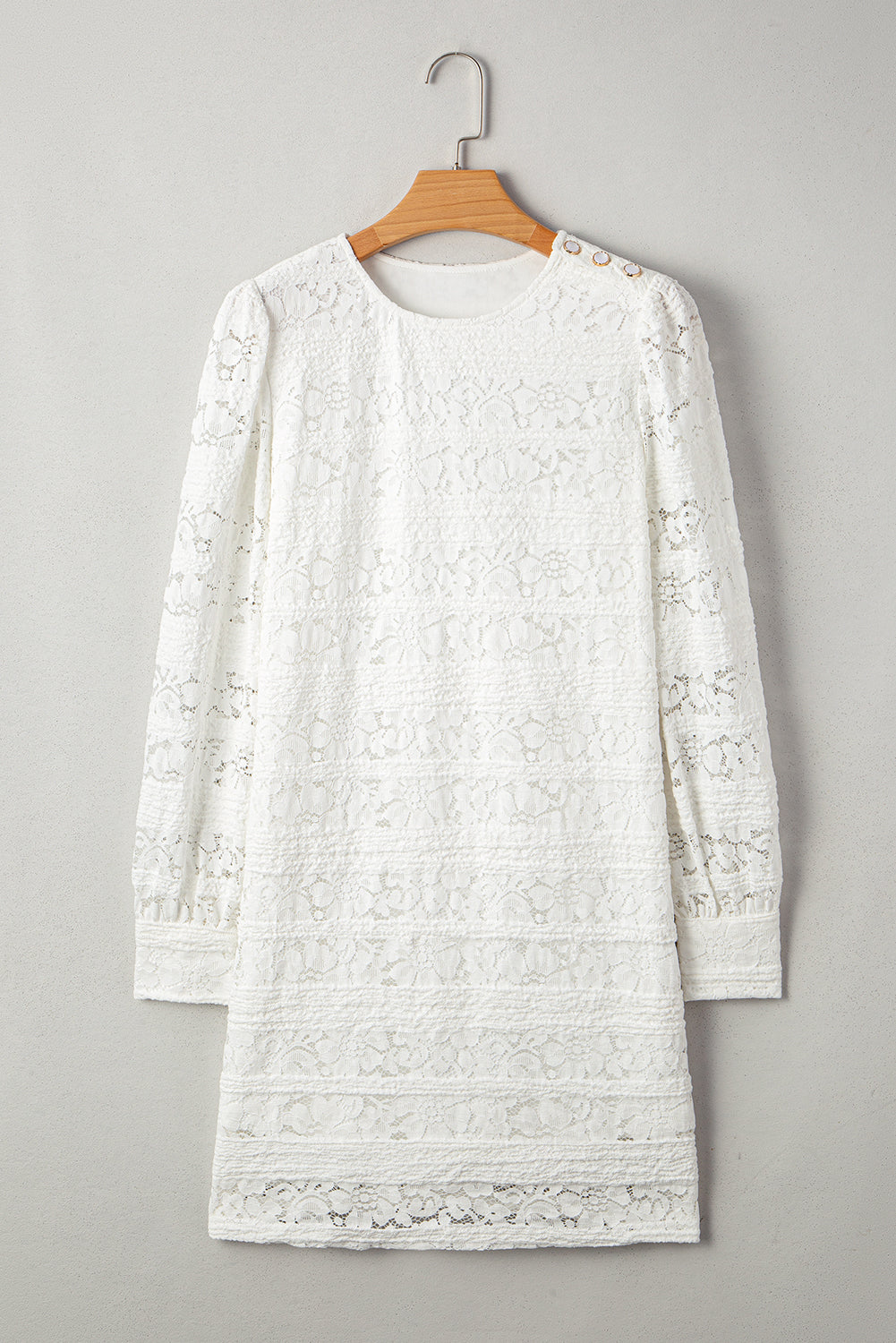 White long sleeve lace dress with floral pattern and decorative shoulder buttons