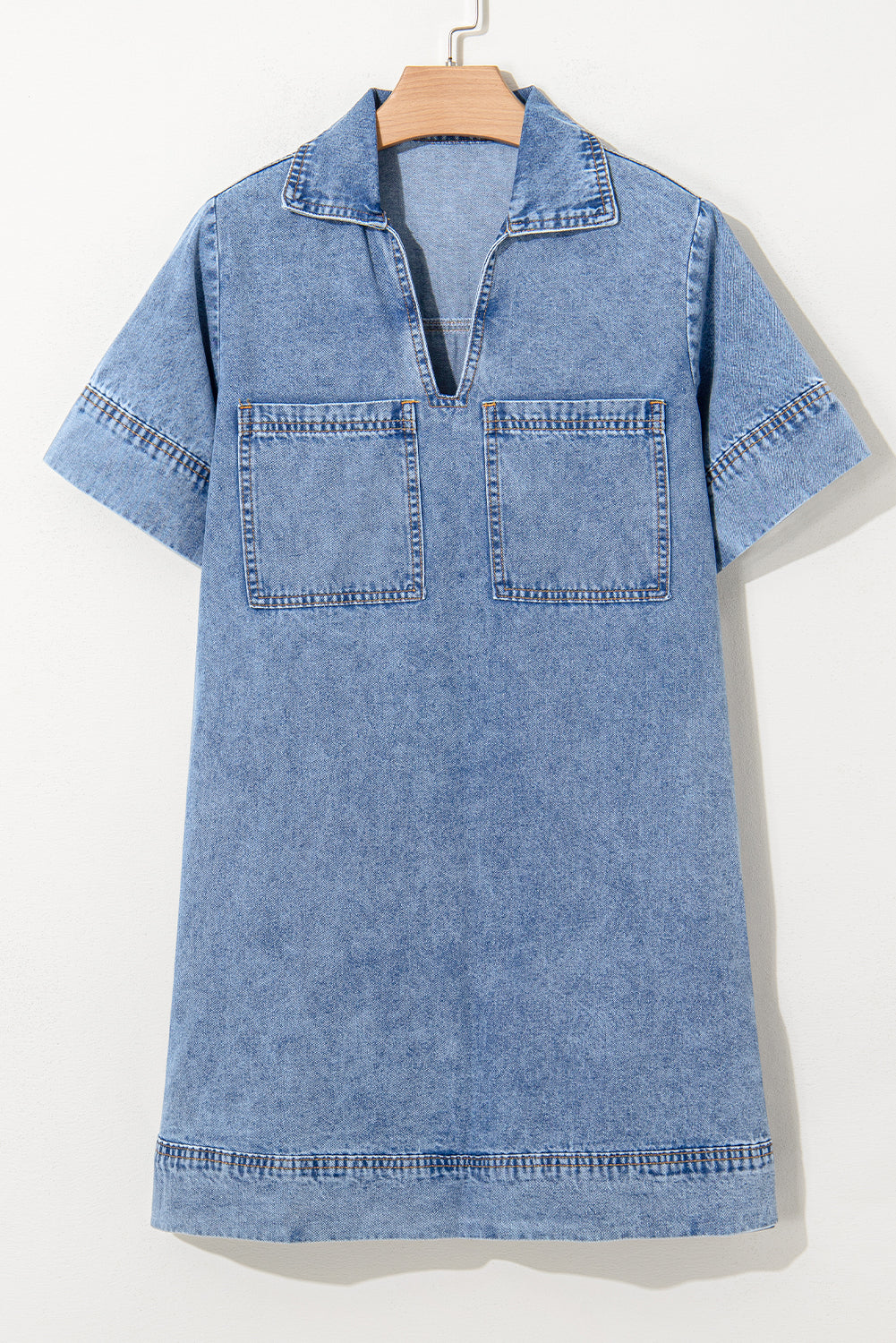 Short sleeve denim dress with collar, front patch pockets, and exposed stitching on hanger
