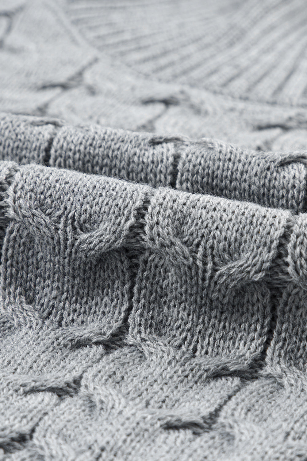 Сив плетен вълнен шал с релефен ромбовиден десен и мека текстура в близък план