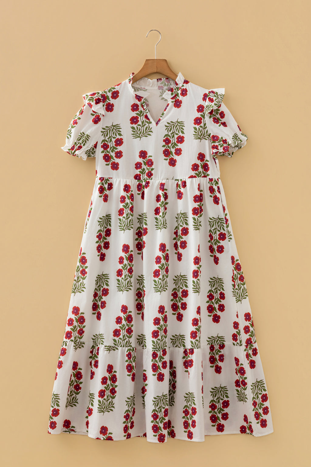 White floral midi dress with red flower print, ruffled short sleeves and v-neck, hanging on hanger