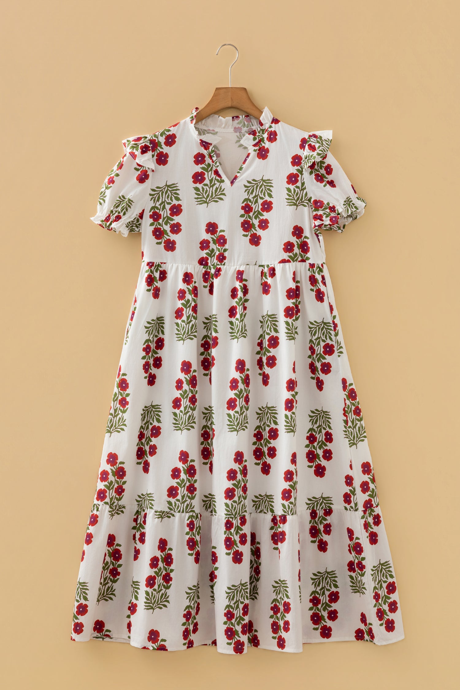 White floral midi dress with red flower print, ruffled short sleeves and v-neck, hanging on hanger