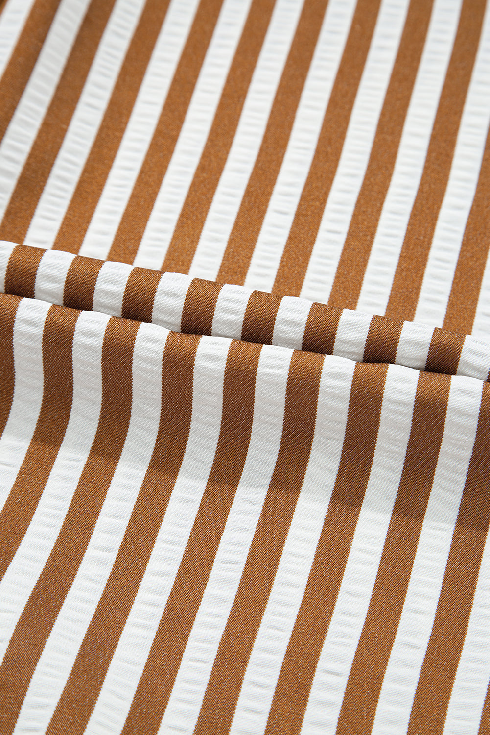 Brown and white striped fabric with textured vertical pattern, close-up view