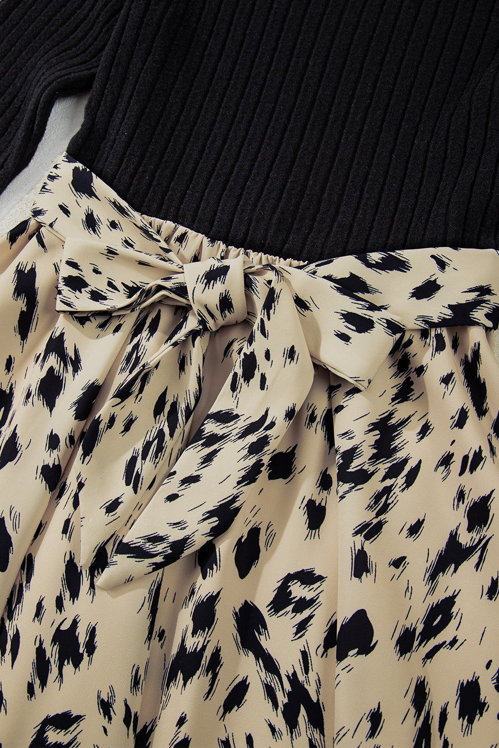 Black ribbed top with beige and black animal print skirt featuring a bow detail