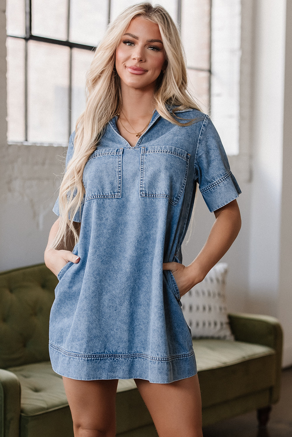 Woman wearing short sleeve denim dress with front pockets, casual indoor setting