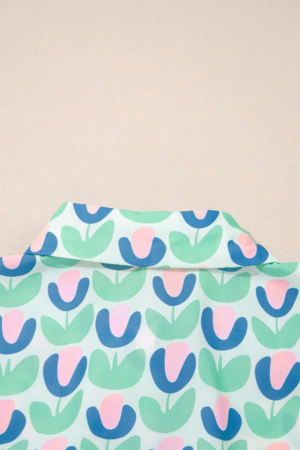 Shirt collar with pastel floral tulip print, featuring green, blue, and pink colors.