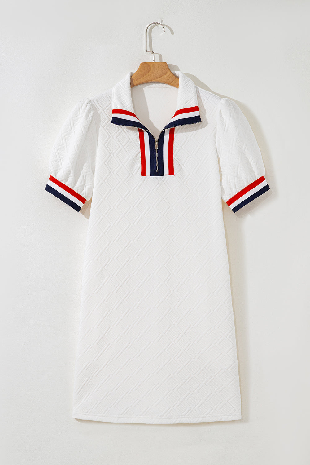 White short-sleeve textured dress with red and navy striped collar and cuffs, zipper front.