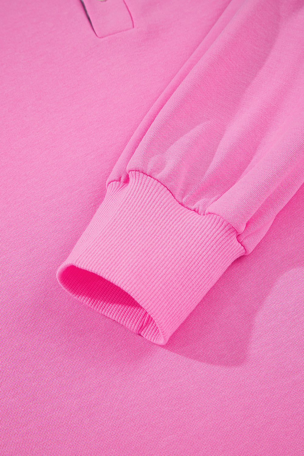 Close-up of pink long sleeve shirt cuff with ribbed knit fabric