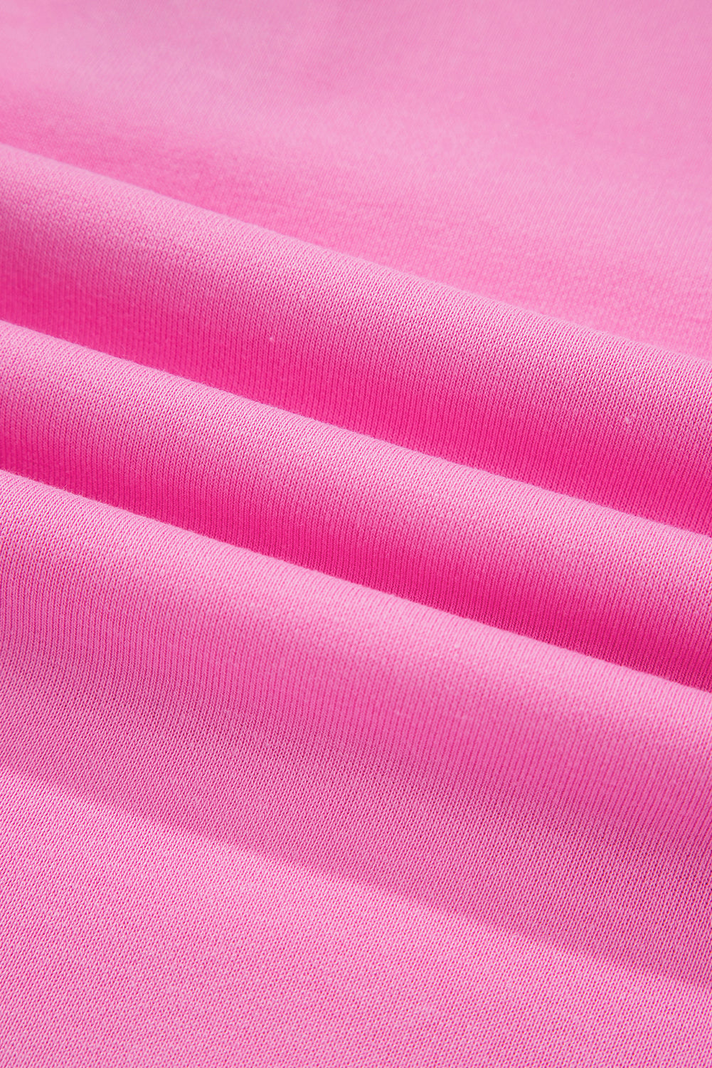 Close-up of soft pink fabric with a smooth texture and visible folds
