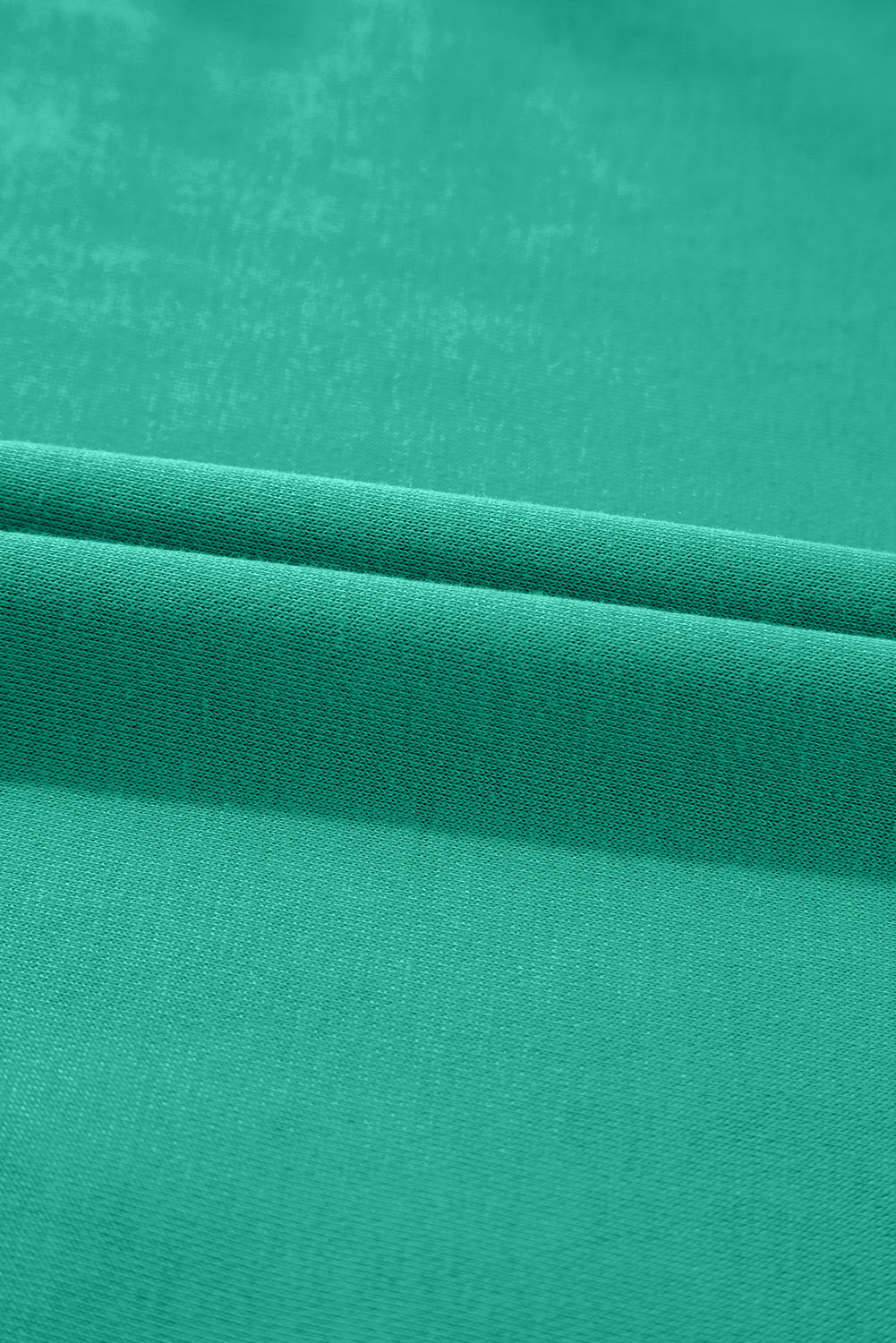 Close-up of folded green fabric with smooth, soft texture