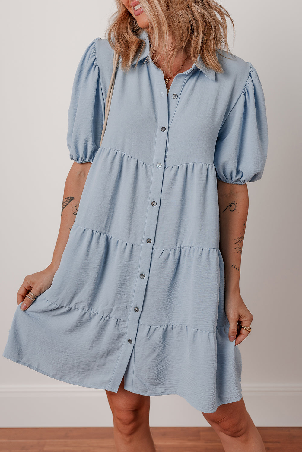 Light blue short-sleeve button-down dress with puff sleeves and tiered design
