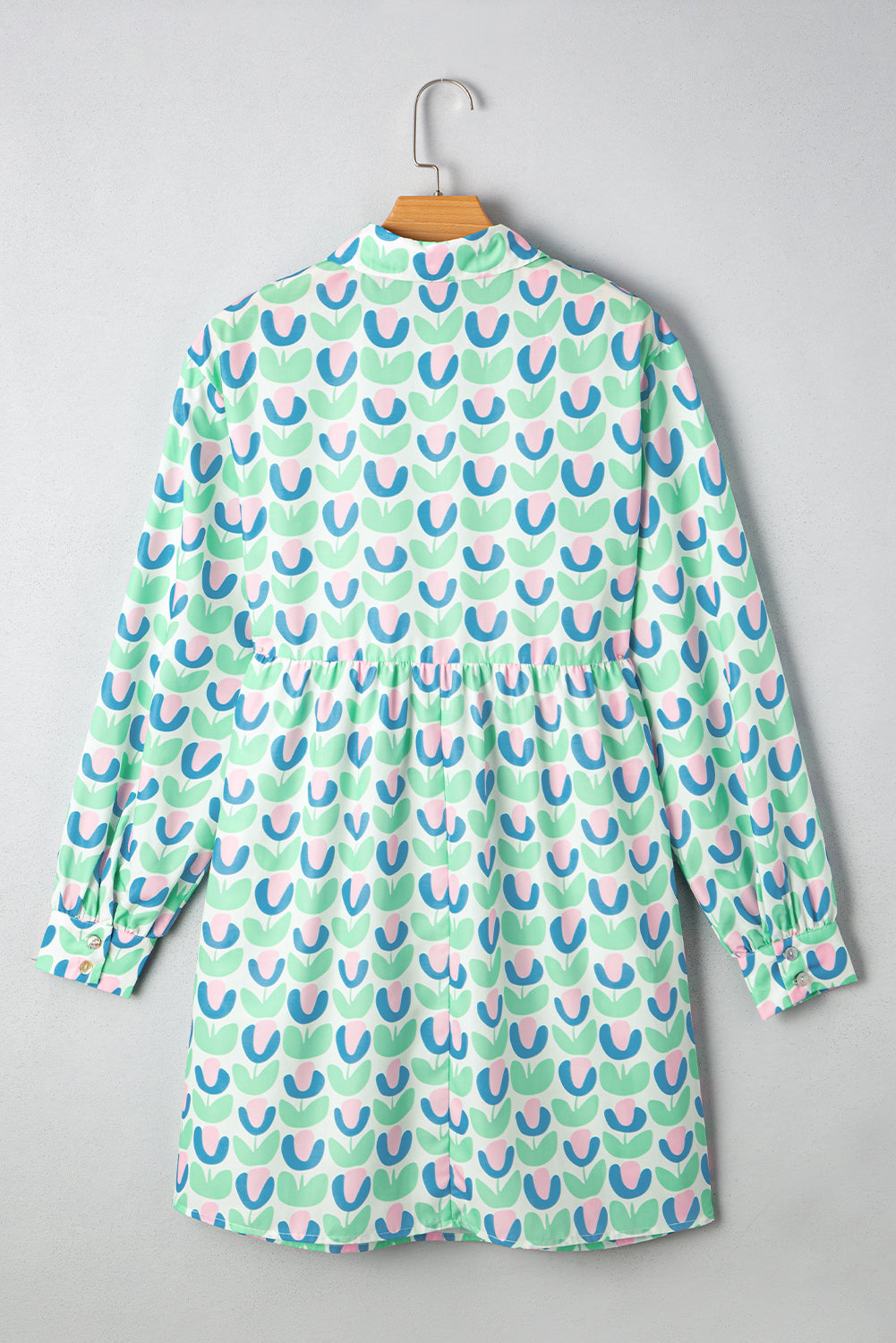 Back view of long sleeve tunic with pastel tulip print, light green, pink, and blue.
