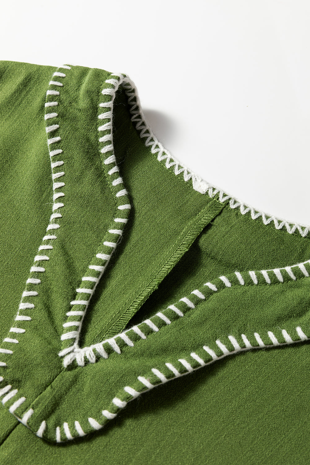 Green V-neck garment with white decorative stitching detail on neckline