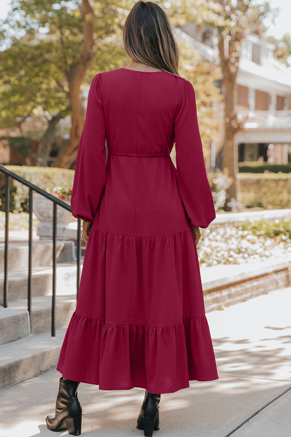 Woman outdoors in long-sleeve burgundy maxi dress with ruffle hem and black boots
