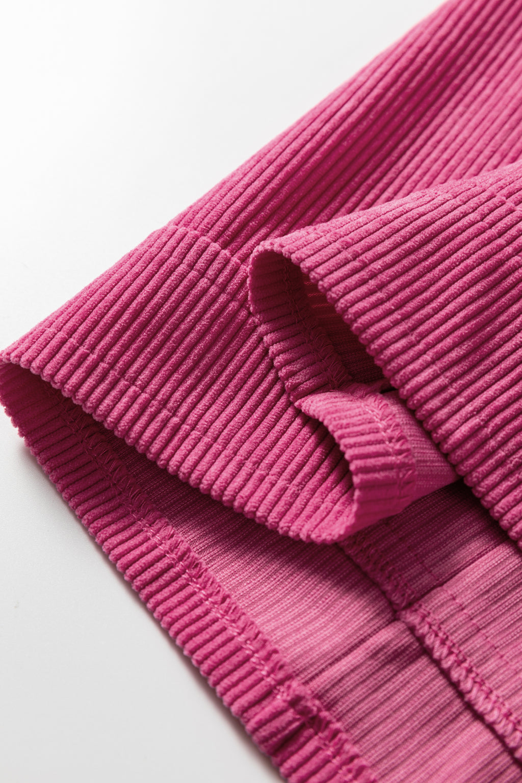 Close-up of pink ribbed knit fabric with visible seam and soft texture
