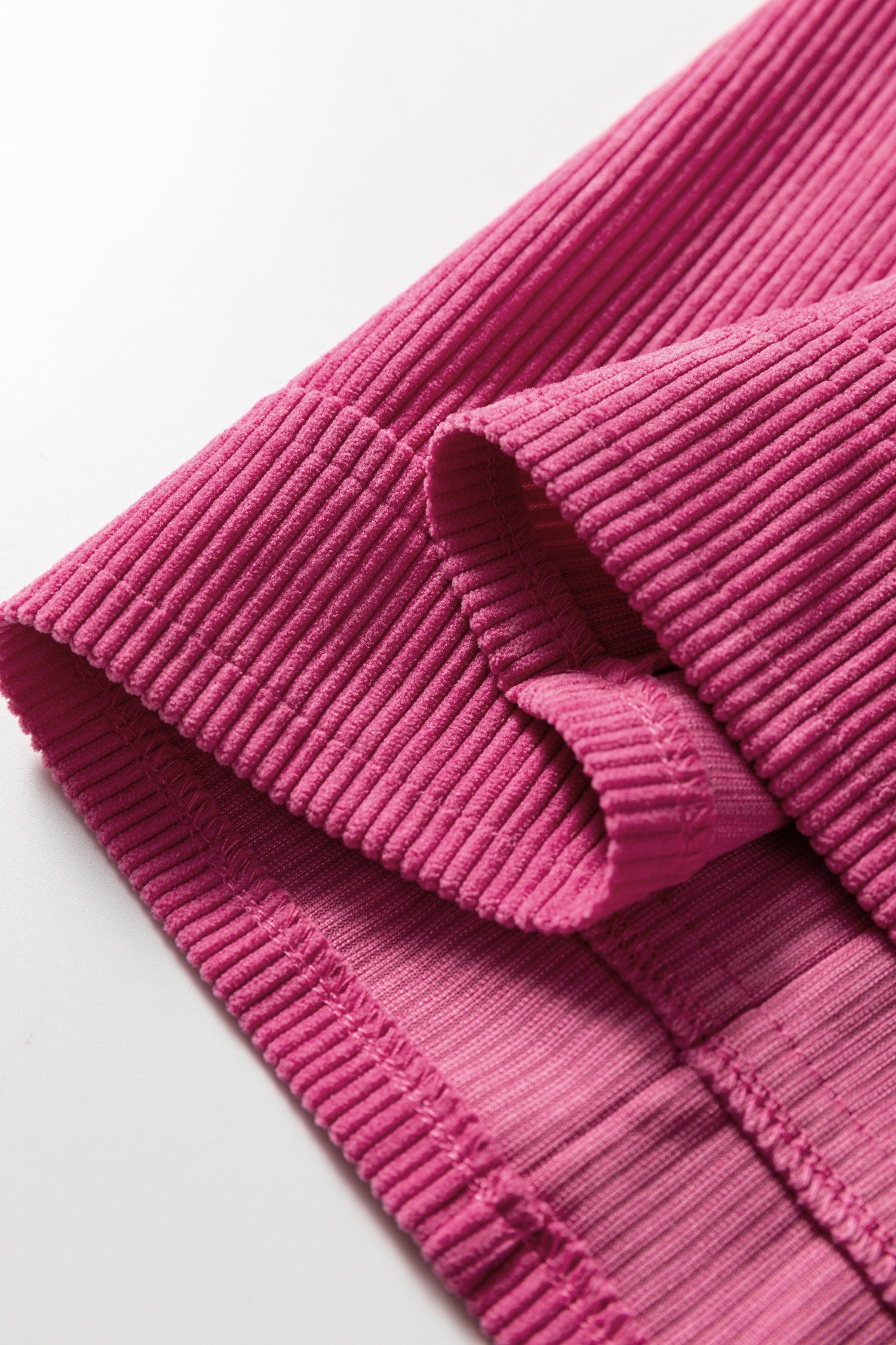 Close-up of pink ribbed knit fabric with visible seam and soft texture