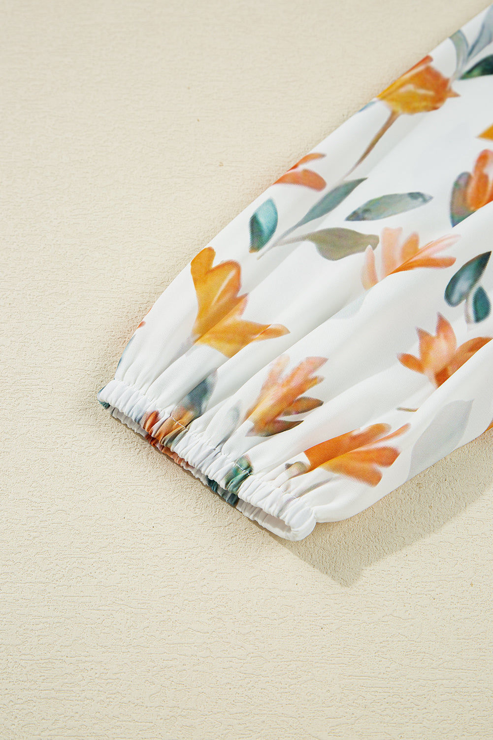 White long sleeve with orange floral print and elastic cuff