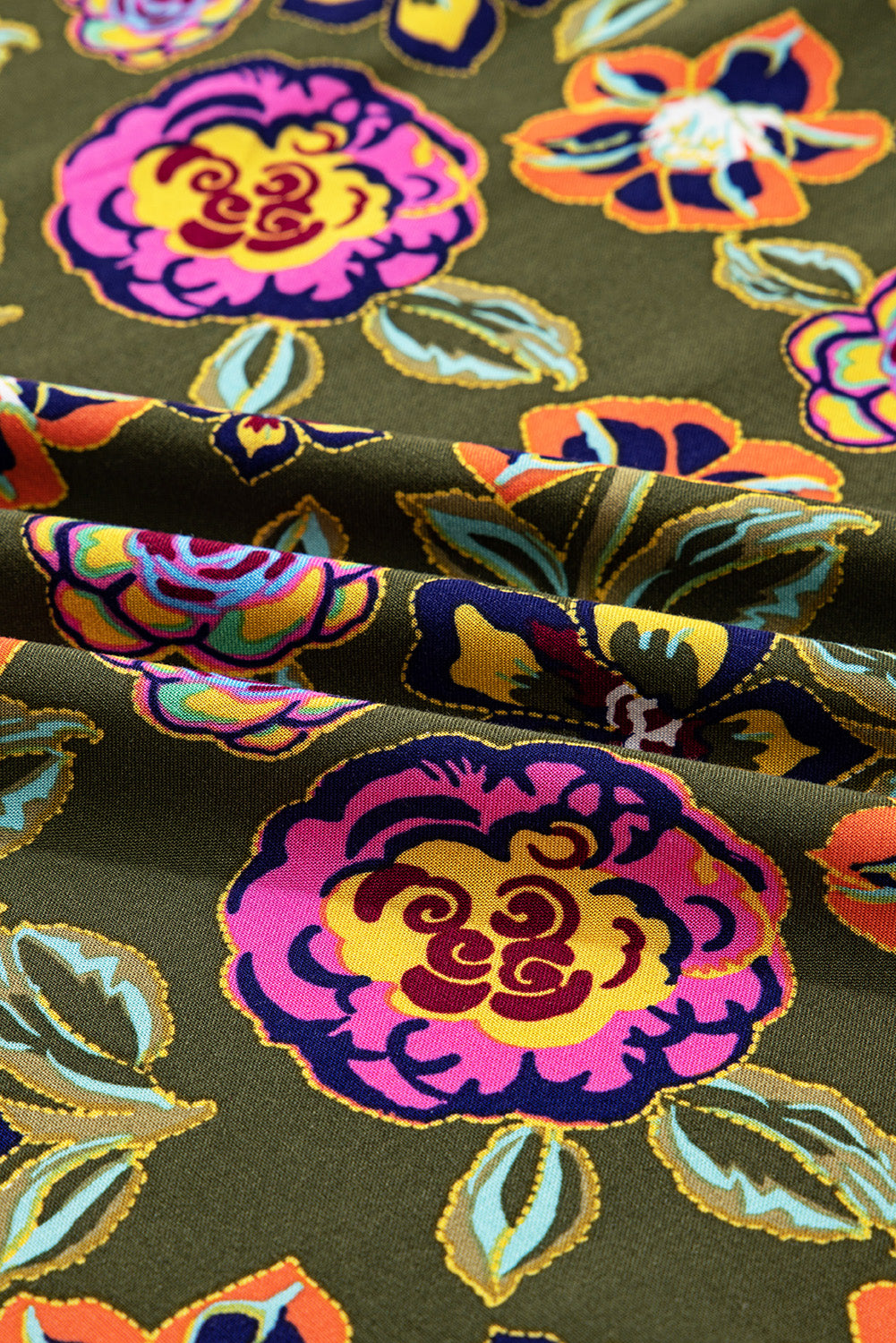 Olive green fabric with vibrant floral print in pink, yellow, blue, and orange colors