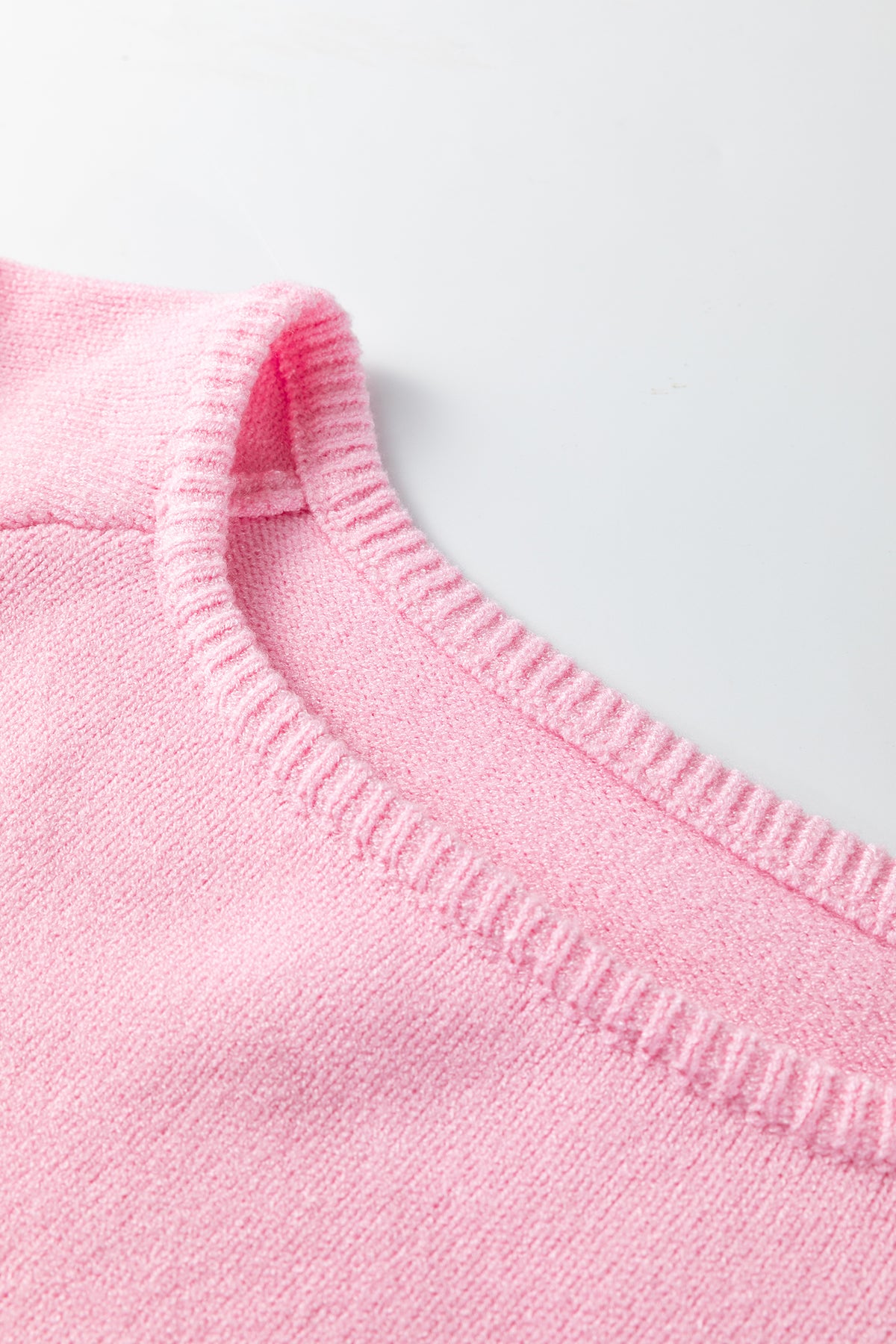 Розов плетен пуловер с V-образно деколте и видим рипсен кант отблизо