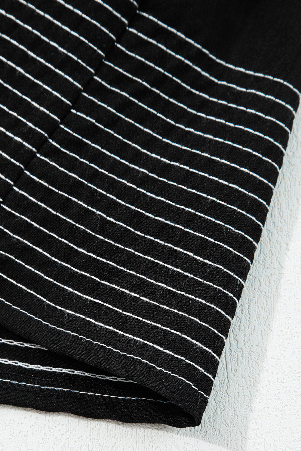 Close-up of black fabric with white horizontal stripes, textured cotton textile