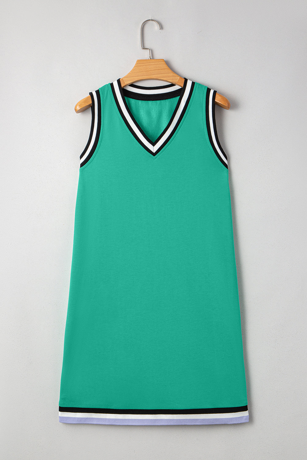 Sleeveless green dress with V-neck and black and white striped trim, hanging on a hanger