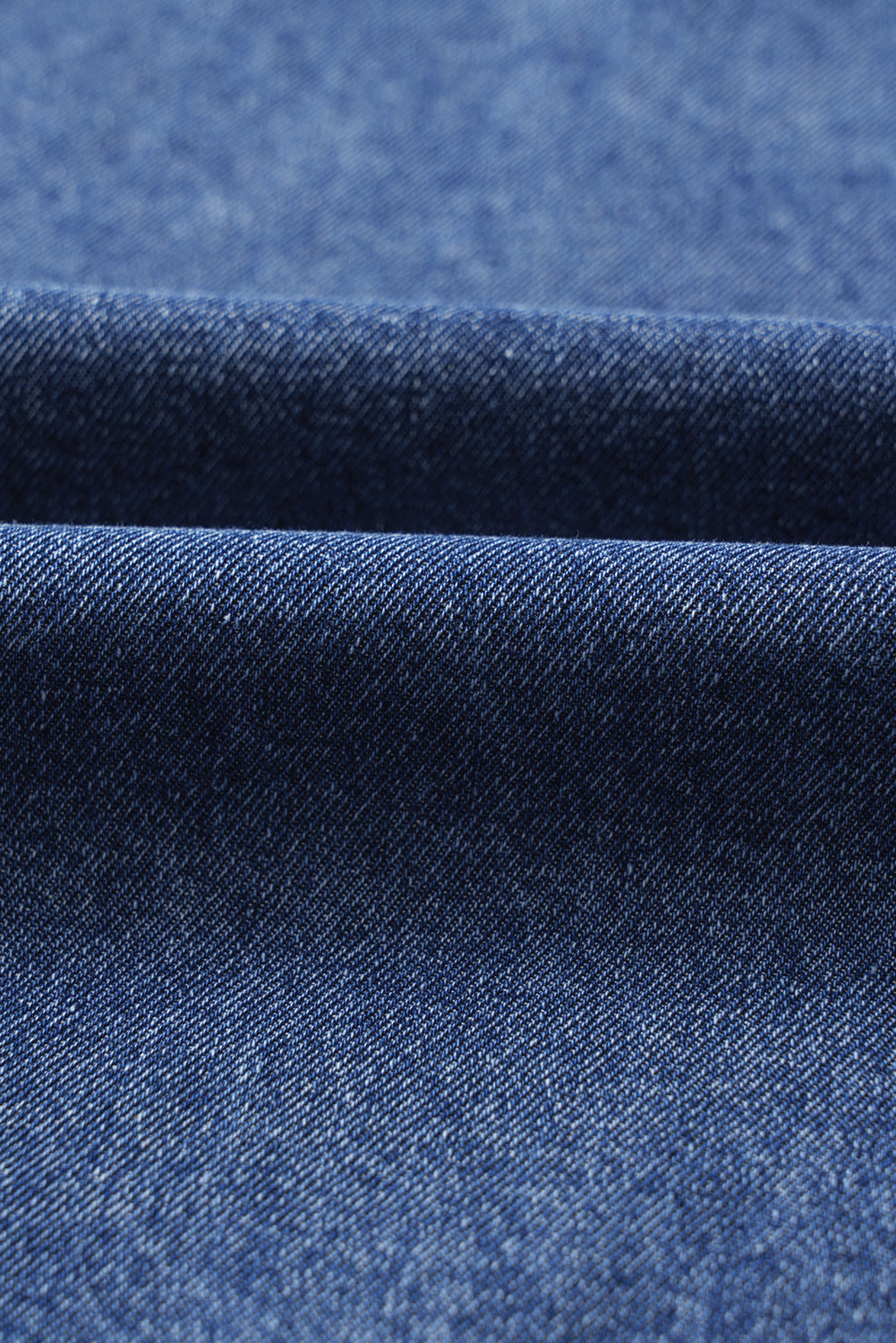Close-up of blue denim fabric texture with visible diagonal weave pattern