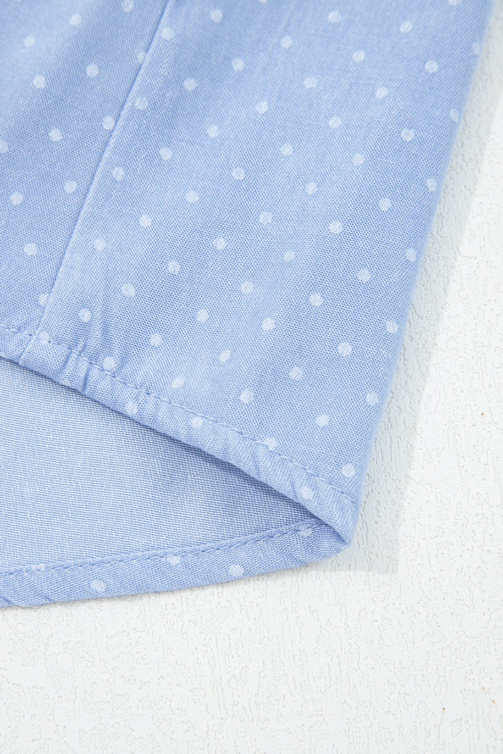 детайл на подгъв на блуза от лек деним с десен на точки