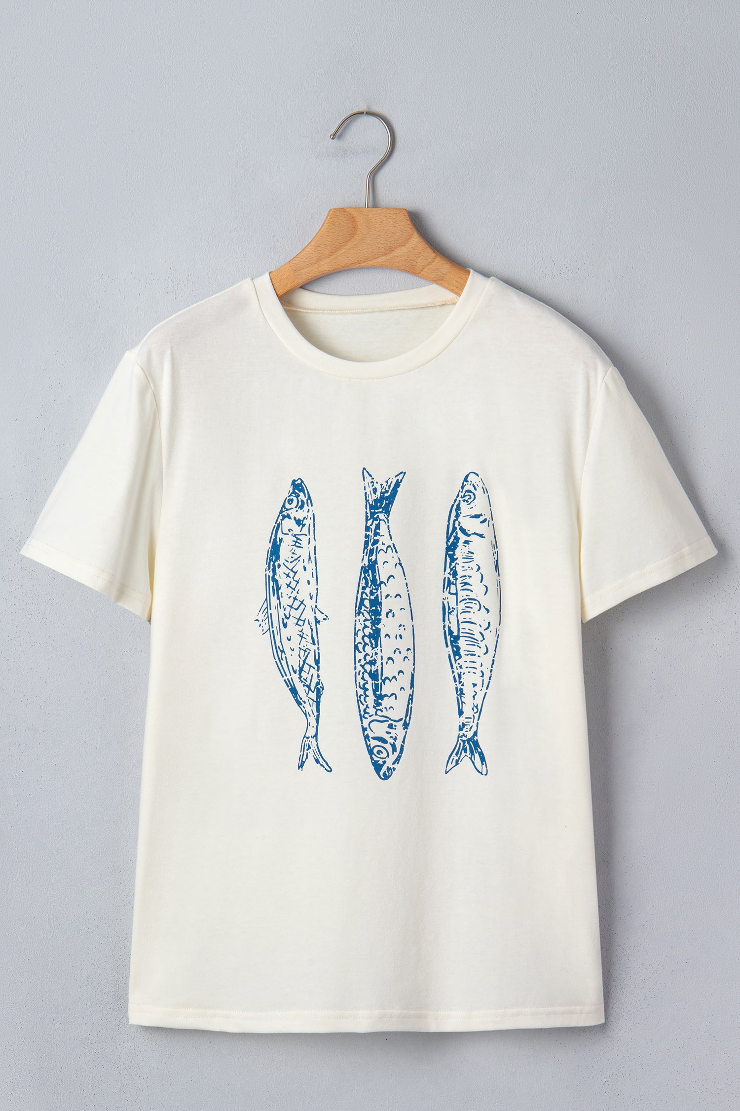 Бежова тениска на закачалка с син принт на три риби в преден изглед
