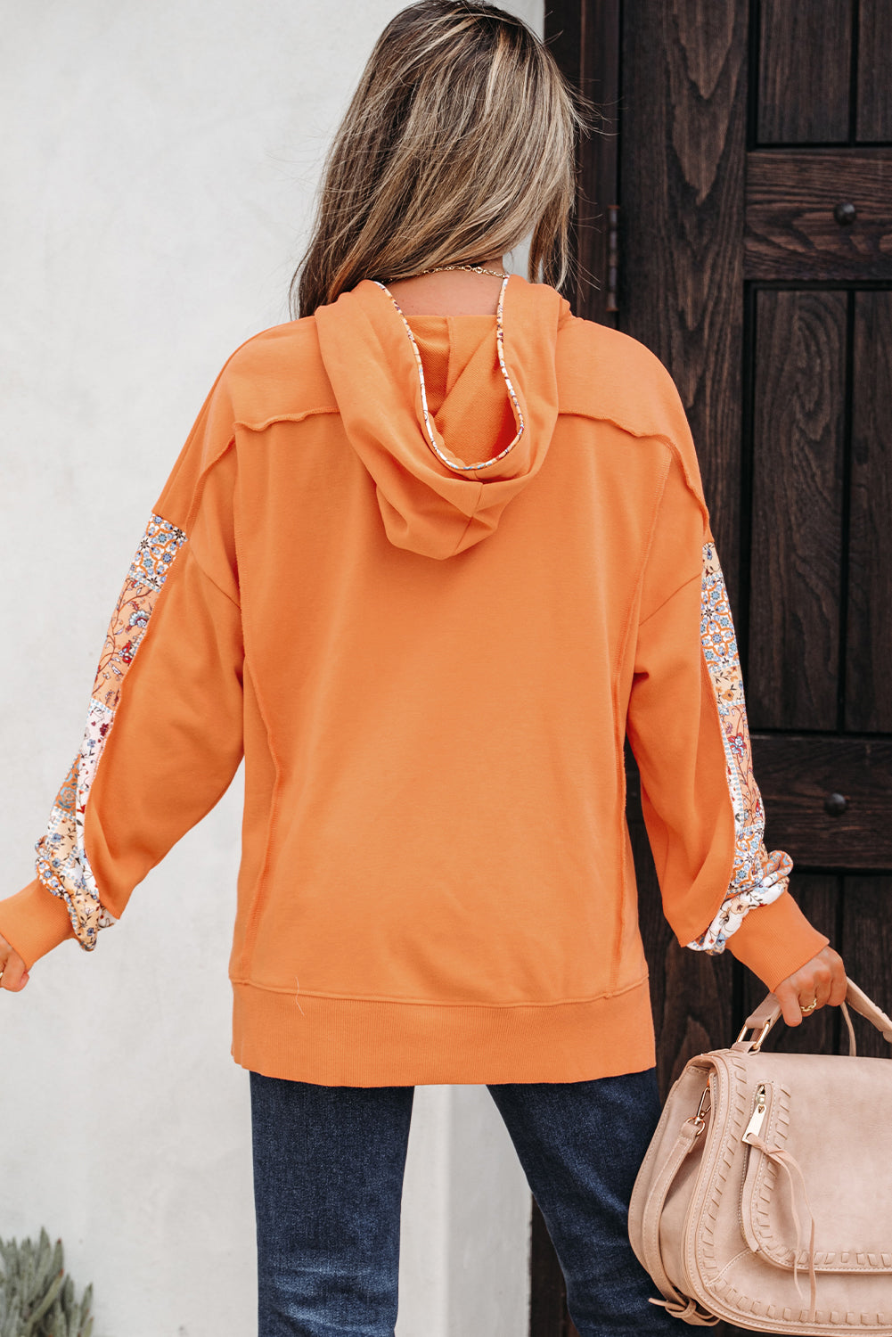 заден изглед на дамски суичър в оранжев цвят с качулка