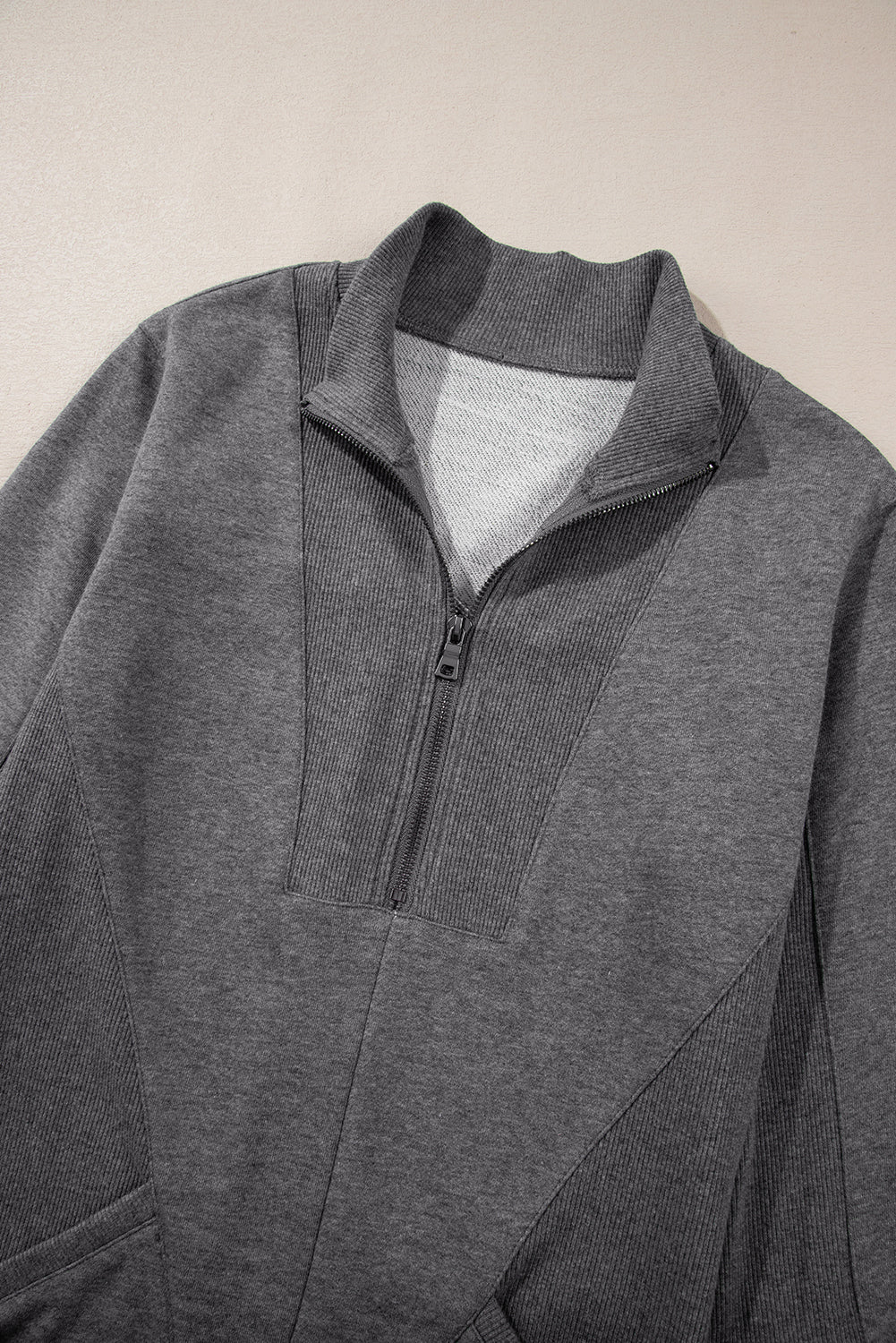 Gray half-zip sweatshirt with ribbed collar and panel details on light background