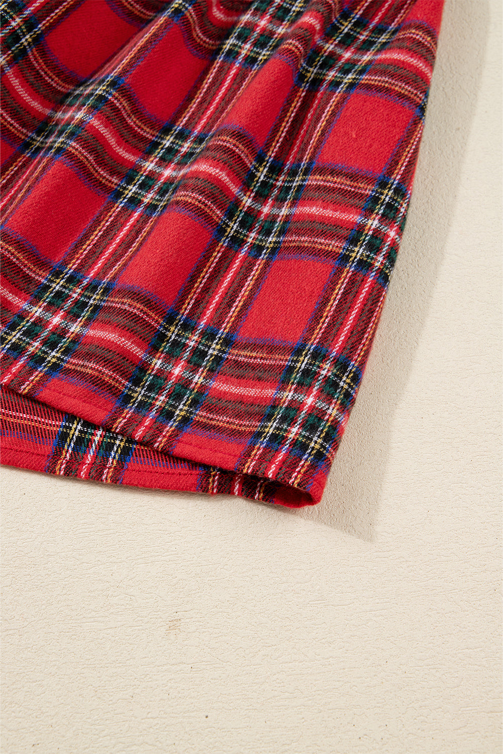 Close-up of red tartan plaid fabric, soft texture with green and blue checks